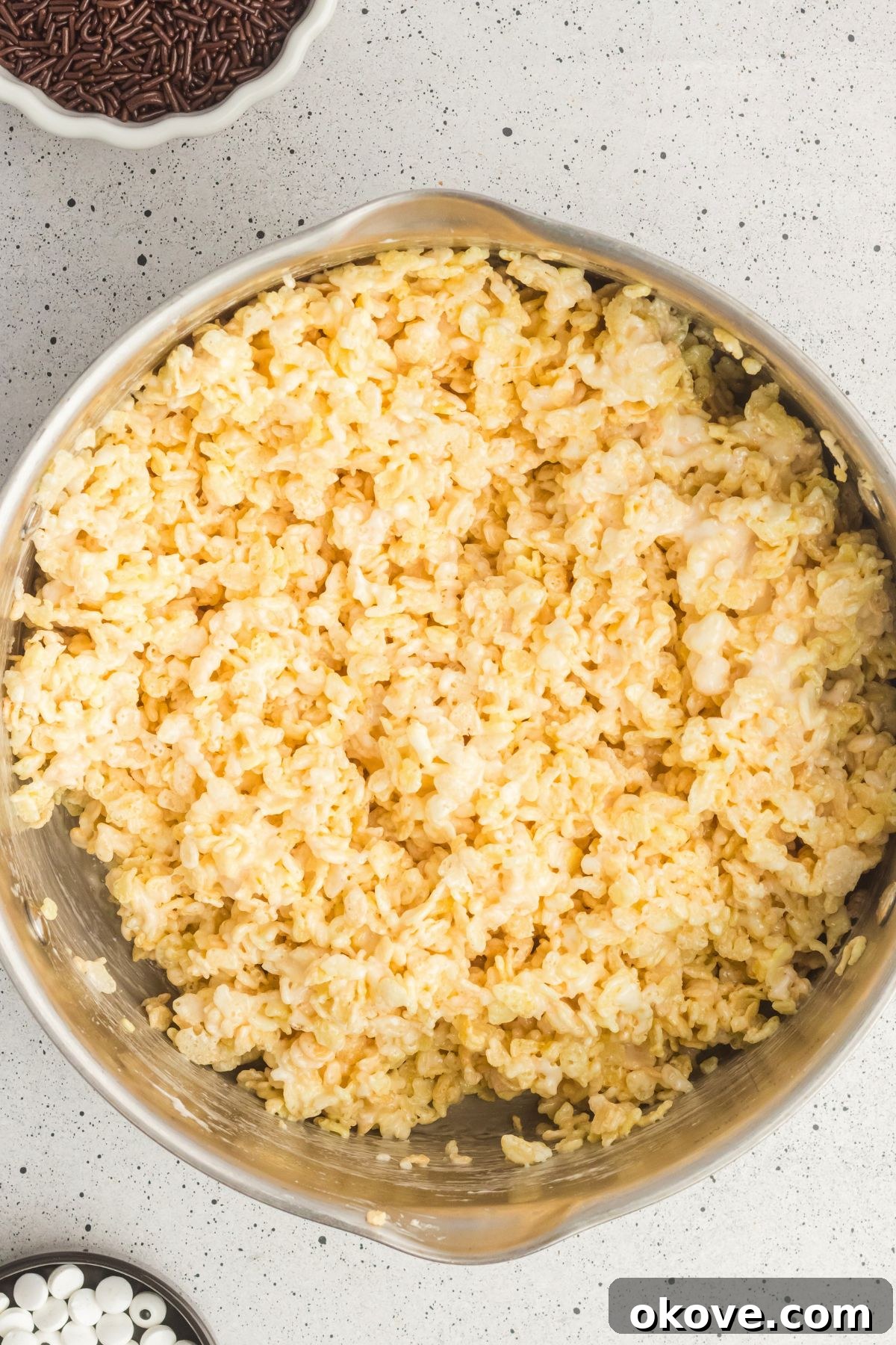 Monster Mash Krispies 5 Rice krispie cereal mixed with melted butter and marshmallows in a large saucepan.