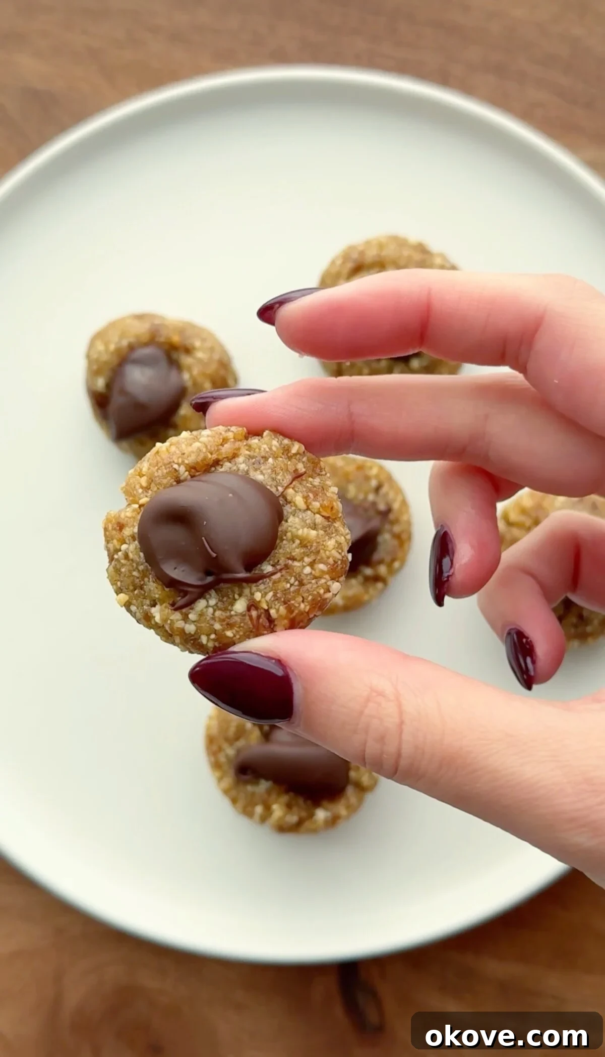 A hand holding simple date bites, demonstrating their perfect size and appeal.
