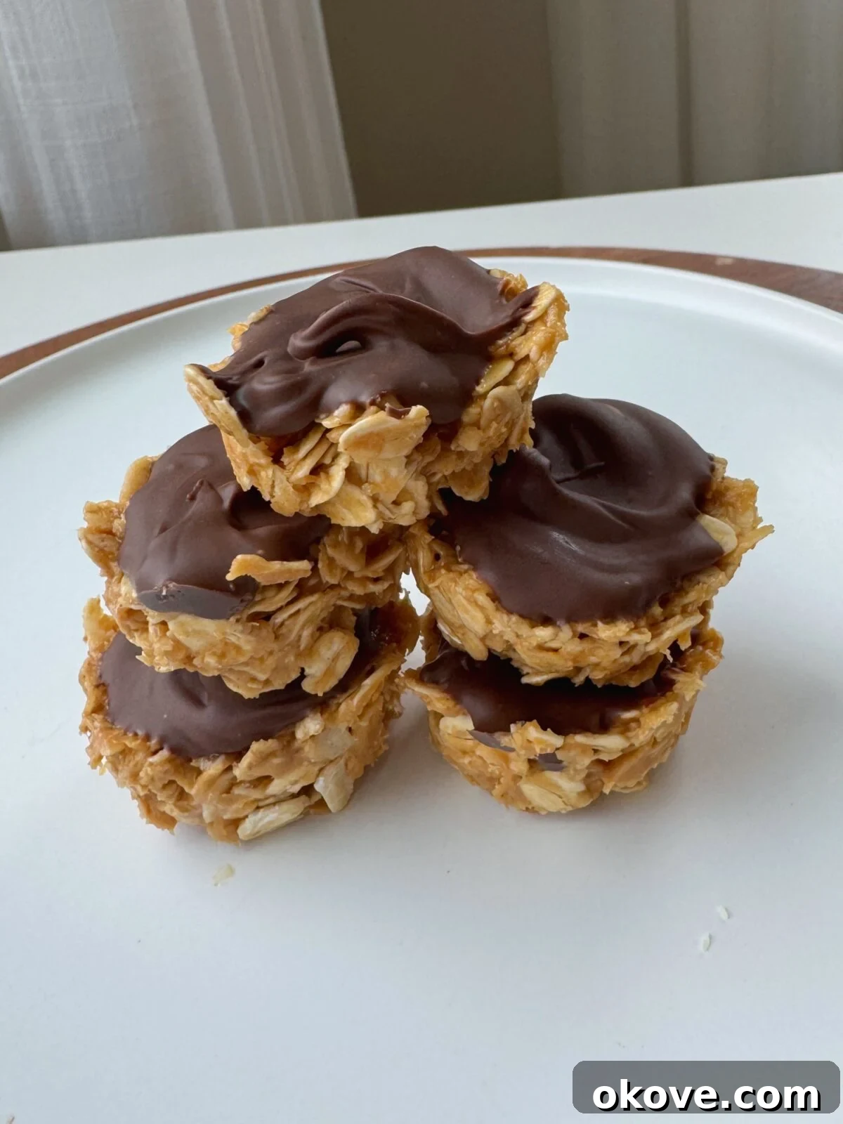 Peanut Butter Oatmeal Bliss Balls 2 A stack of easy, no-bake peanut butter oat bites for toddlers, topped with a thin layer of chocolate.