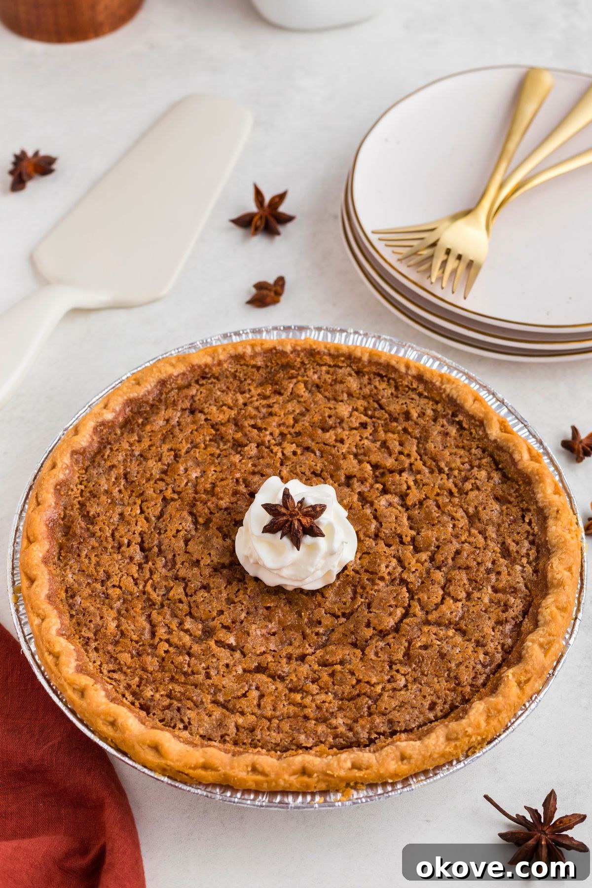 Classic Sweet Potato Pie 2 Whole sweet potato pie topped with fresh whipped cream and a sprinkle of cinnamon on a elegant marble table, ready to be served.