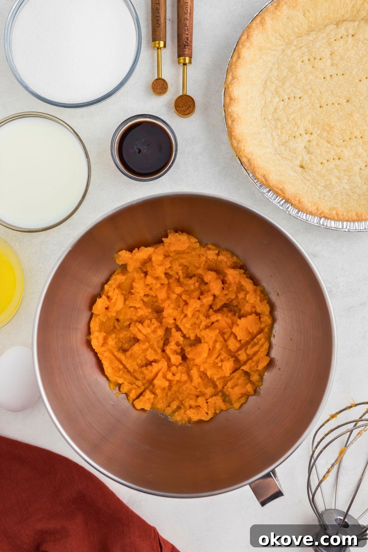 Classic Sweet Potato Pie 4 Freshly mashed sweet potatoes, smooth and creamy, in a large silver mixing bowl, ready for the next ingredients.