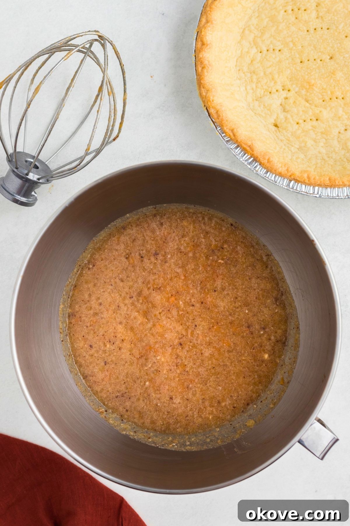 Classic Sweet Potato Pie 5 The smooth, creamy sweet potato pie filling, fully mixed with eggs, milk, butter, and spices, in a silver mixing bowl, awaiting transfer to the crust.