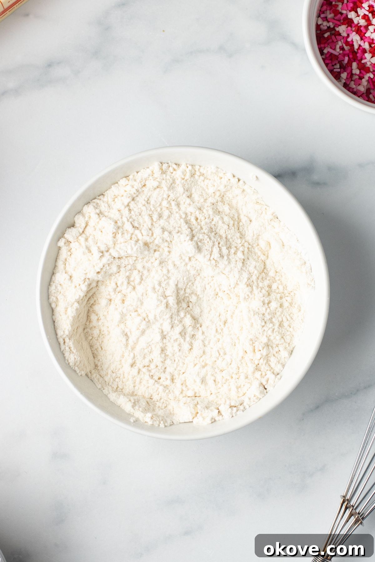 Blushing Sweet Treats 4 Dry ingredients for cupcakes mixed in white mixing bowls.