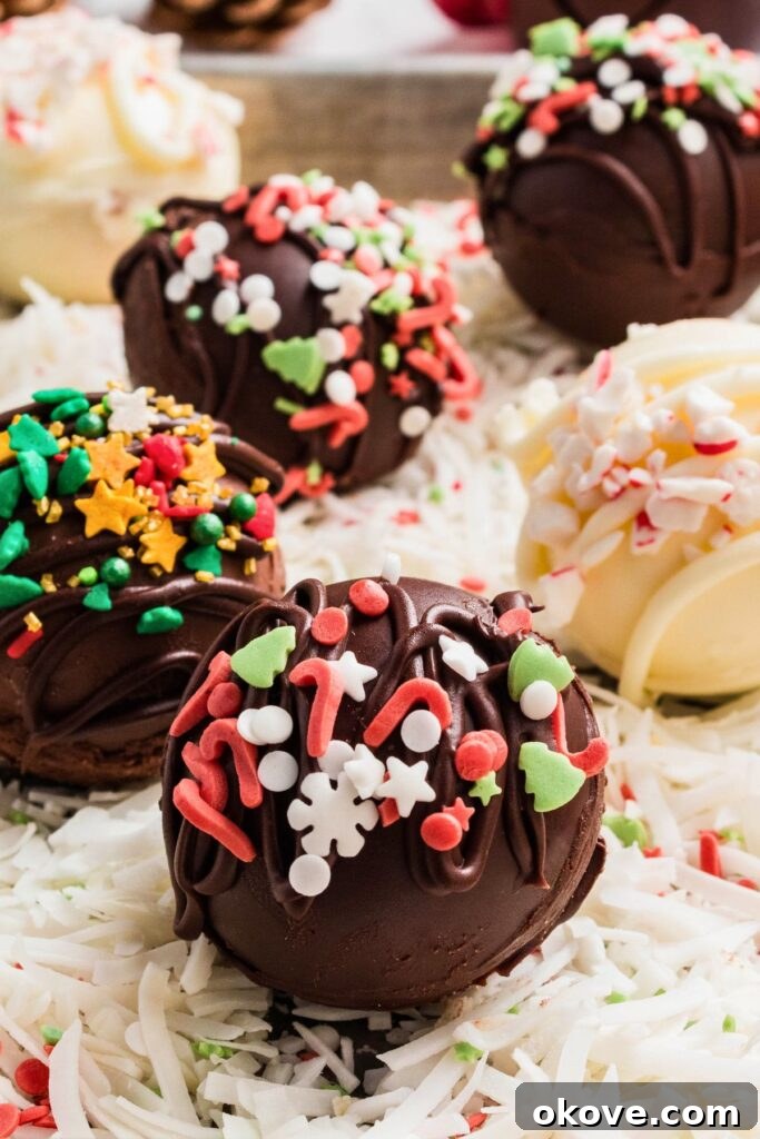 Gourmet Cocoa Melts 3 Milk chocolate cocoa bombs with holiday sprinkles on a table.