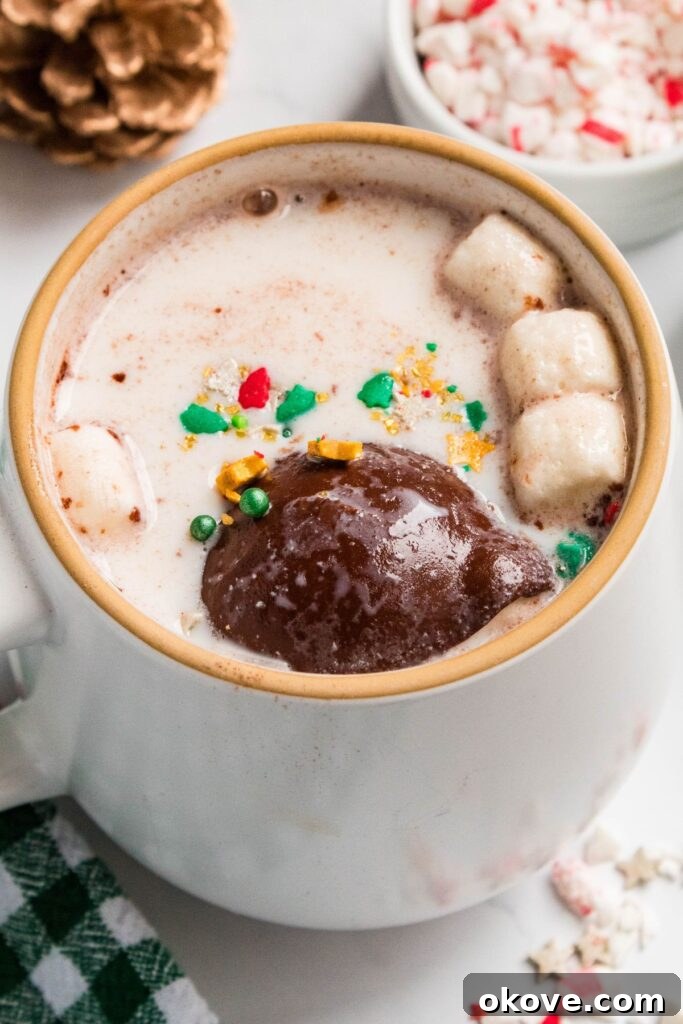 Gourmet Cocoa Melts 9 Cocoa bomb in a mug of hot milk with sprinkles and mini marshmallows.