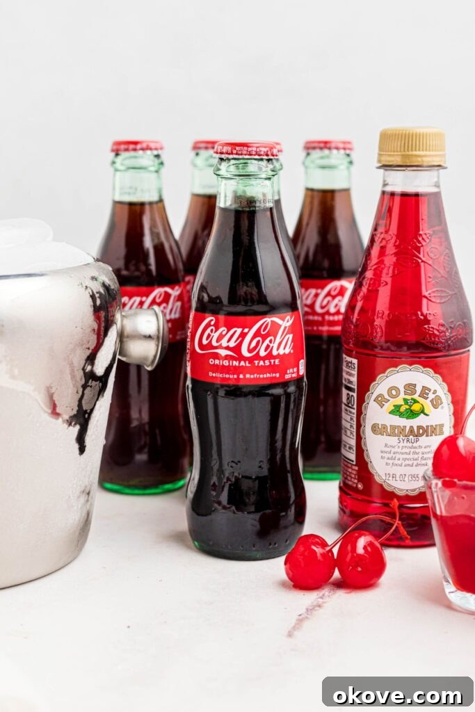 Saddle Up Soda 3 Cola, grenadine syrup, cherries, and ice on a marble table.