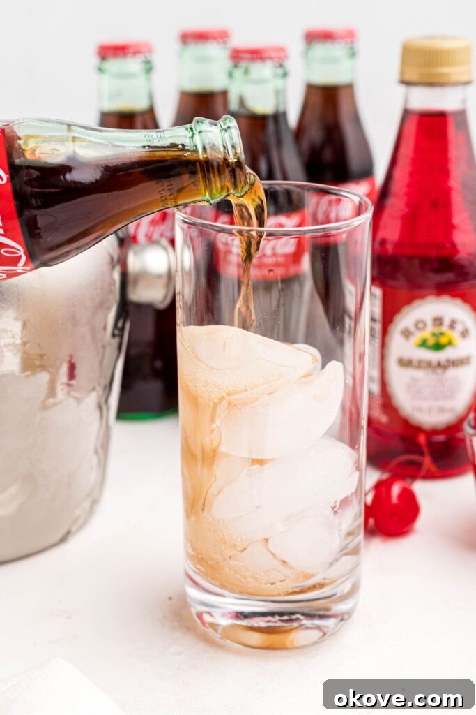 Saddle Up Soda 4 Cola being poured over ice in a highball glass.