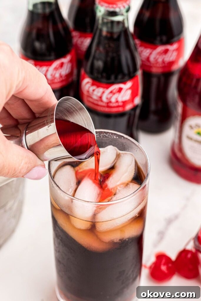 Saddle Up Soda 5 Grenadine syrup being poured over cola and ice in a high ball glass.