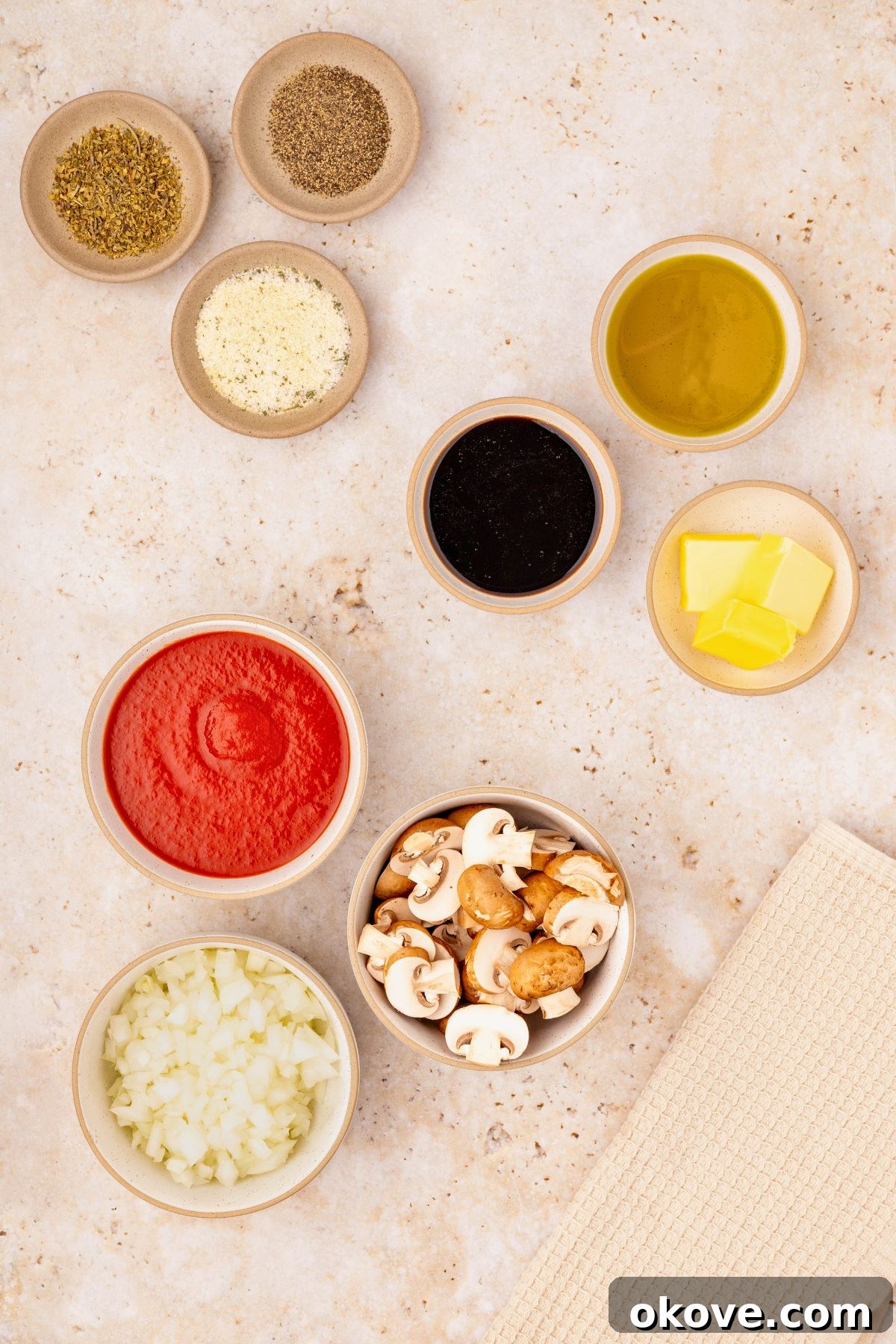 Classic Italian Meatloaf 3 Ingredients needed to make meatloaf measured in small glass bowls on a marble table.