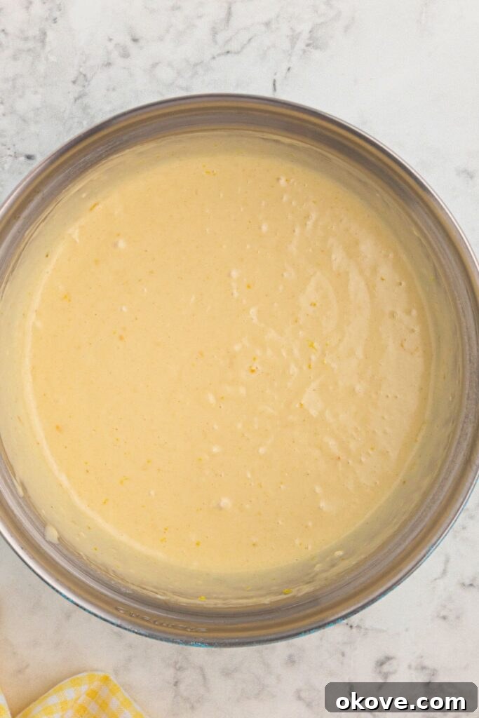 Pancake batter mixed in a large clear glass bowl. 