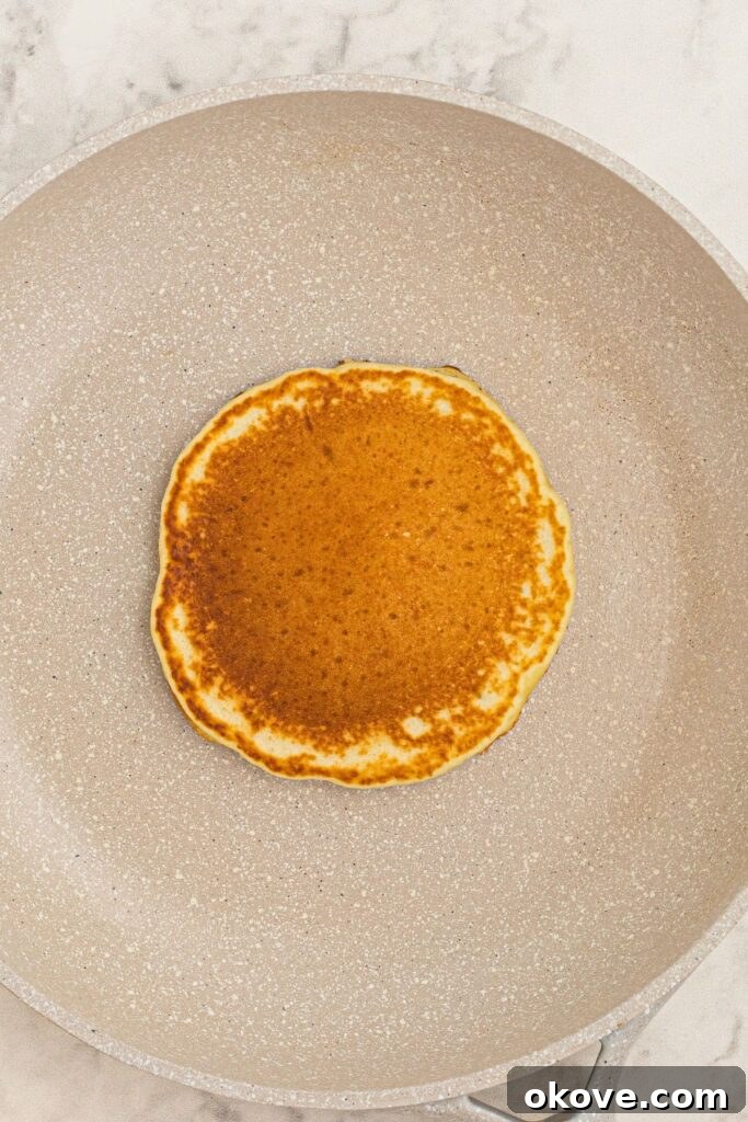 Golden lemon pancake cooked in the middle of a skillet. 