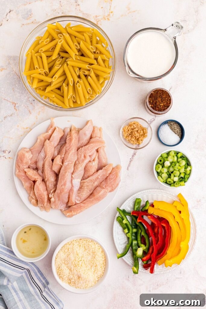 Vibrant Jerk Pasta 3 Carefully measured ingredients for Rasta Pasta laid out on a clean marble countertop, including uncooked pasta, raw chicken, various bell peppers, and essential spices.