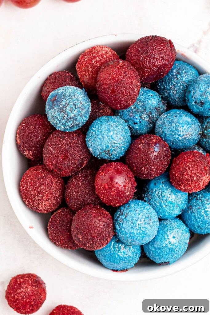 Frosted Grape Jewels 6 A bowl of red and blue grapes coated in flavored powders, stacked invitingly in a white bowl.