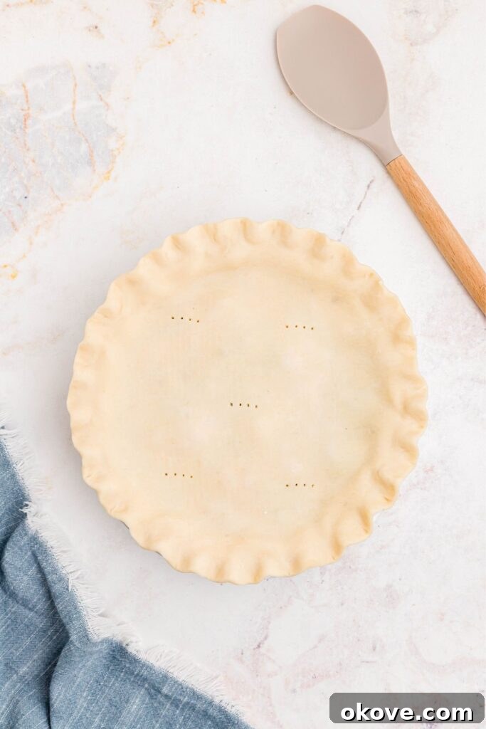 Quick and Cozy Chicken Pot Pie 6 Unbaked chicken pot pie, topped with a second pie crust and vented with fork pricks, ready for the oven.