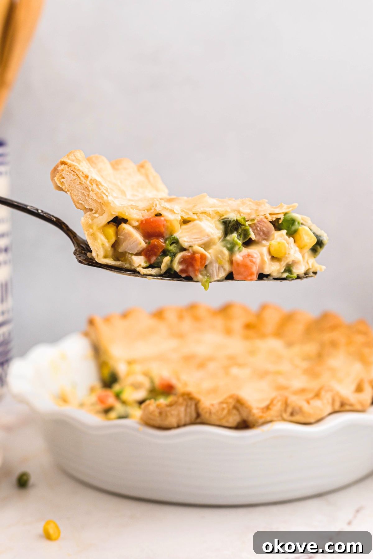 Quick and Cozy Chicken Pot Pie 8 Creamy chicken pot pie with a flaky crust, being served from the pie dish with a spatula.
