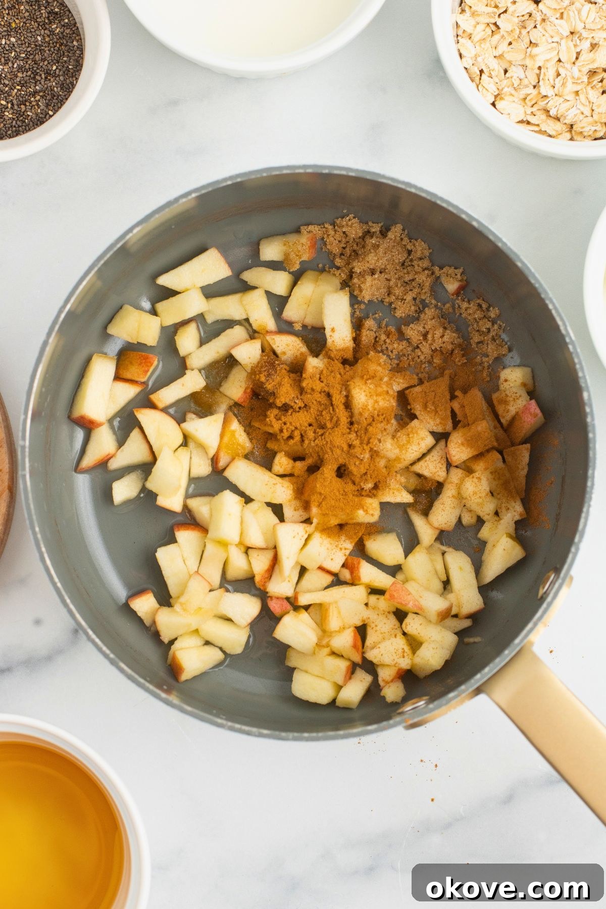 Overnight Apple Pie Bliss 4 Apples and spices in a saucepan before being cooked to soften.