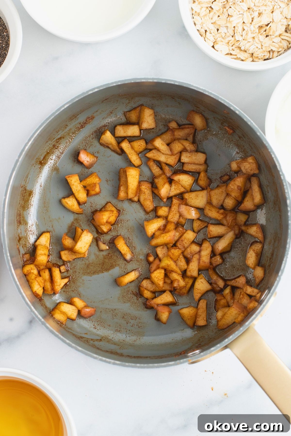 Overnight Apple Pie Bliss 5 Cooked apples in a saucepan, coated with spices.