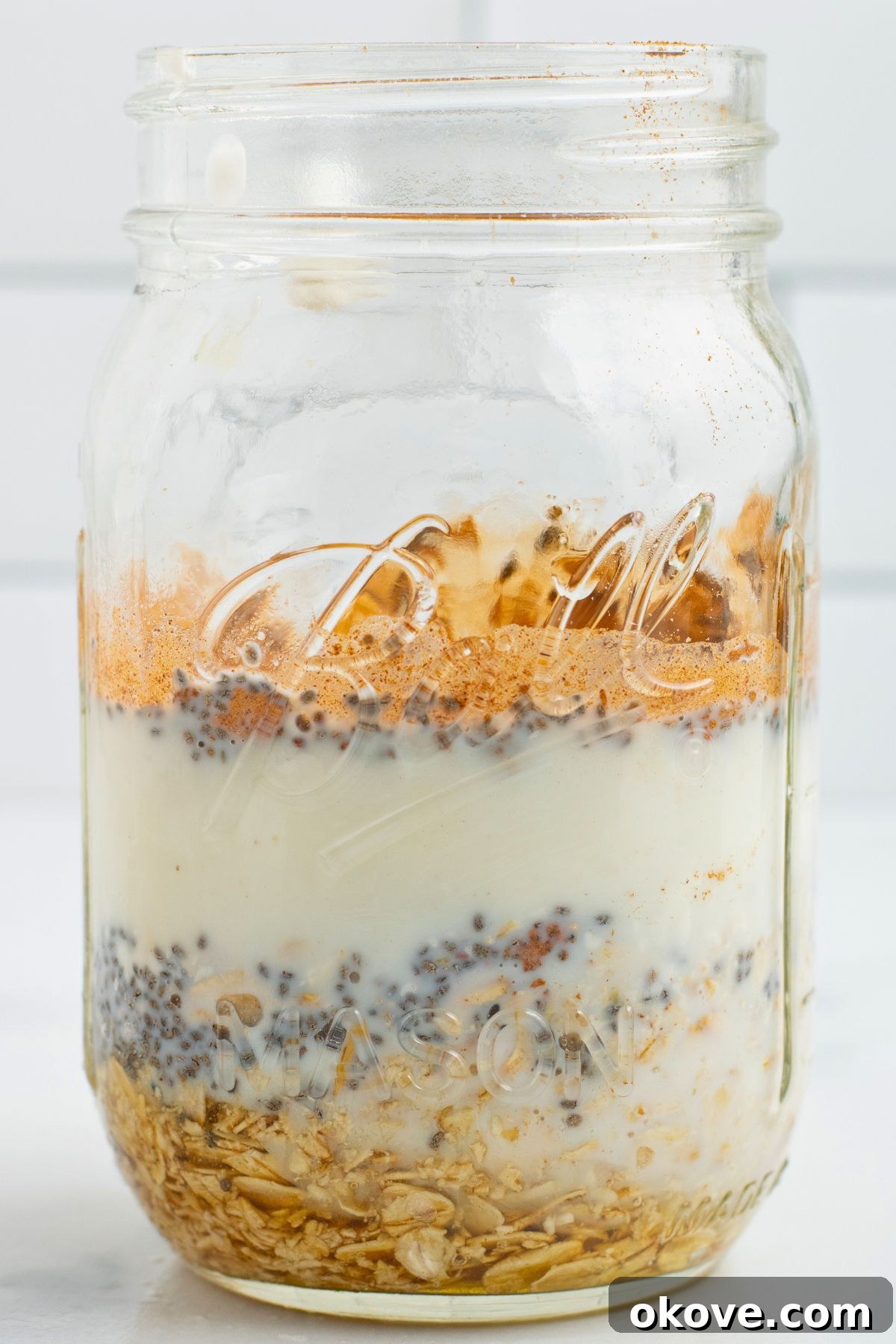 Overnight Apple Pie Bliss 6 Layers of oats, yogurt, and fruit, in a clear mason glass.