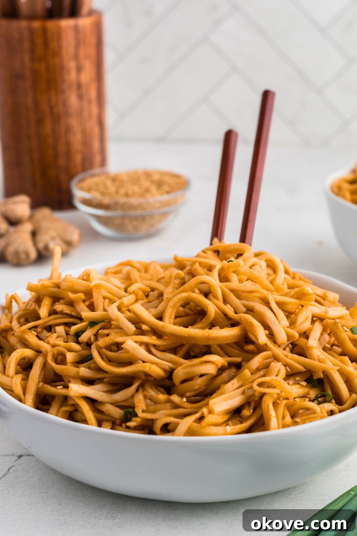 Blazing Noodle Bliss 6 Spicy noodles served in a white bowl topped with chopsticks.