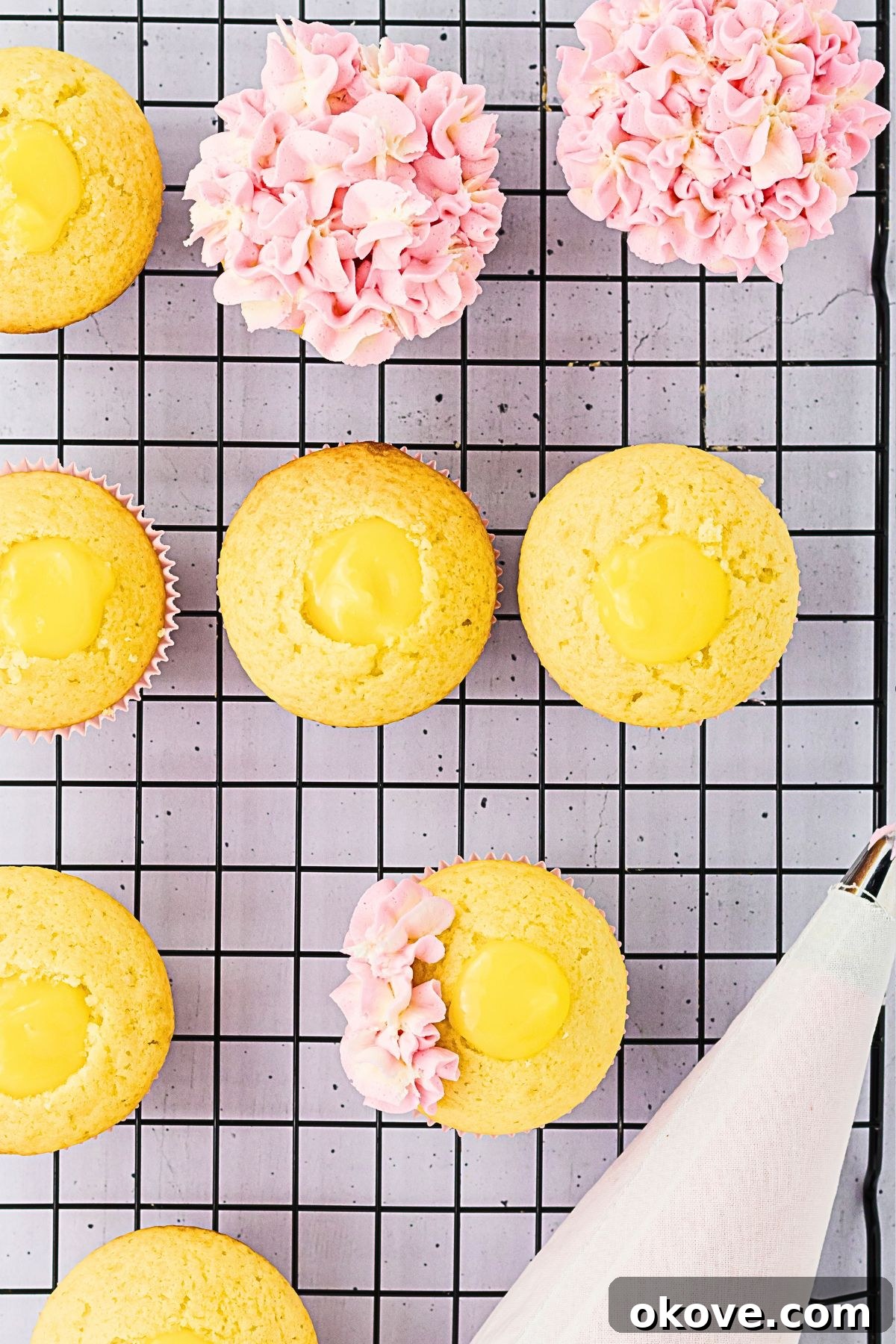 Vanilla cupcakes being frosted with pink and white combined frosting to make hydrangea cupcakes. 