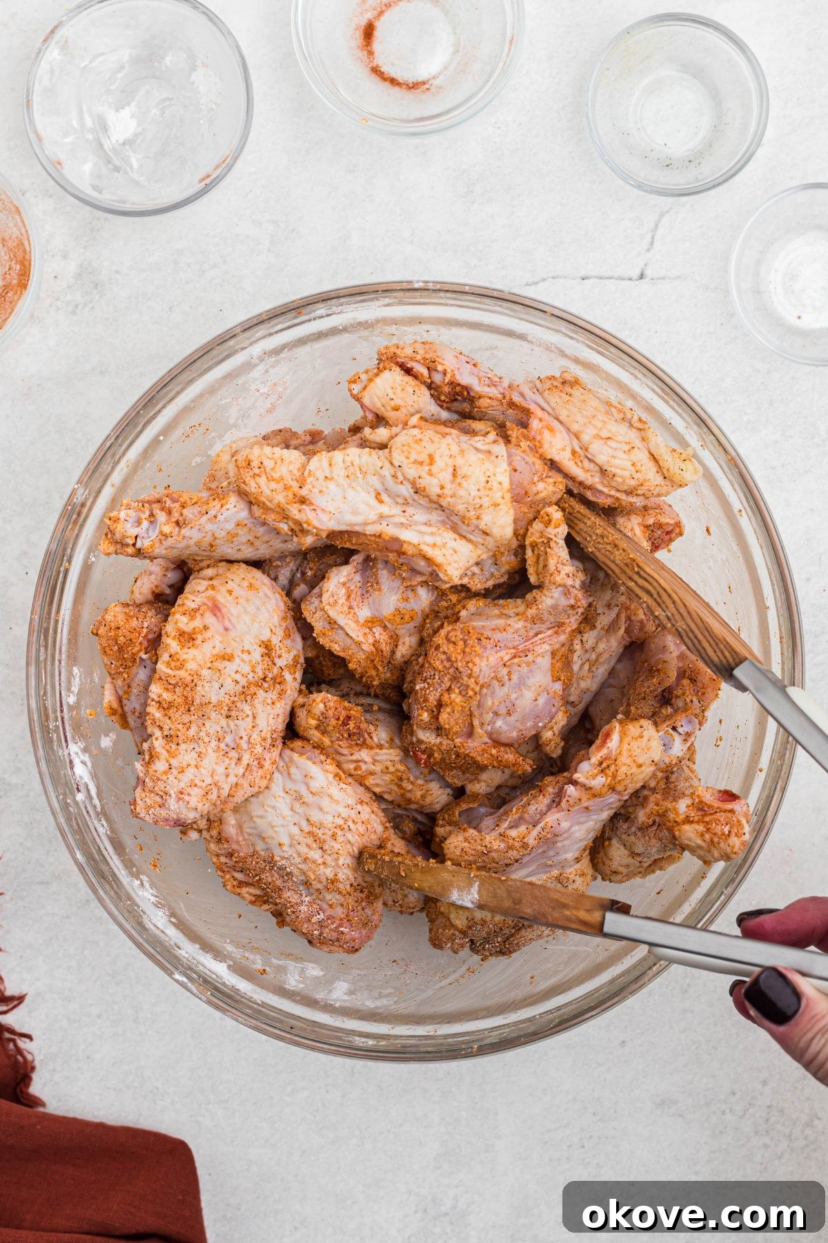 Golden Crispy Wings 4 Uncooked chicken wings, thoroughly tossed in a dry seasoning blend including baking powder, and arranged neatly on a wire rack over a baking sheet.