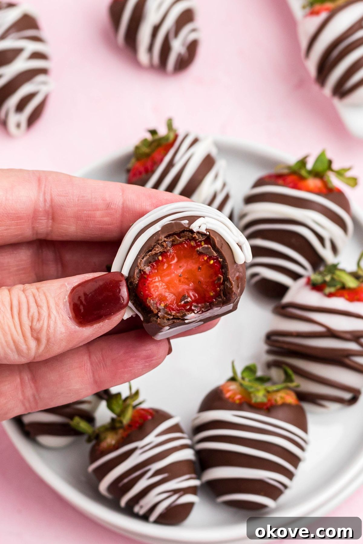 Effortless Chocolate Strawberry Delights 7 One chocolate dipped strawberry being held after a bite has been removed showing the center.