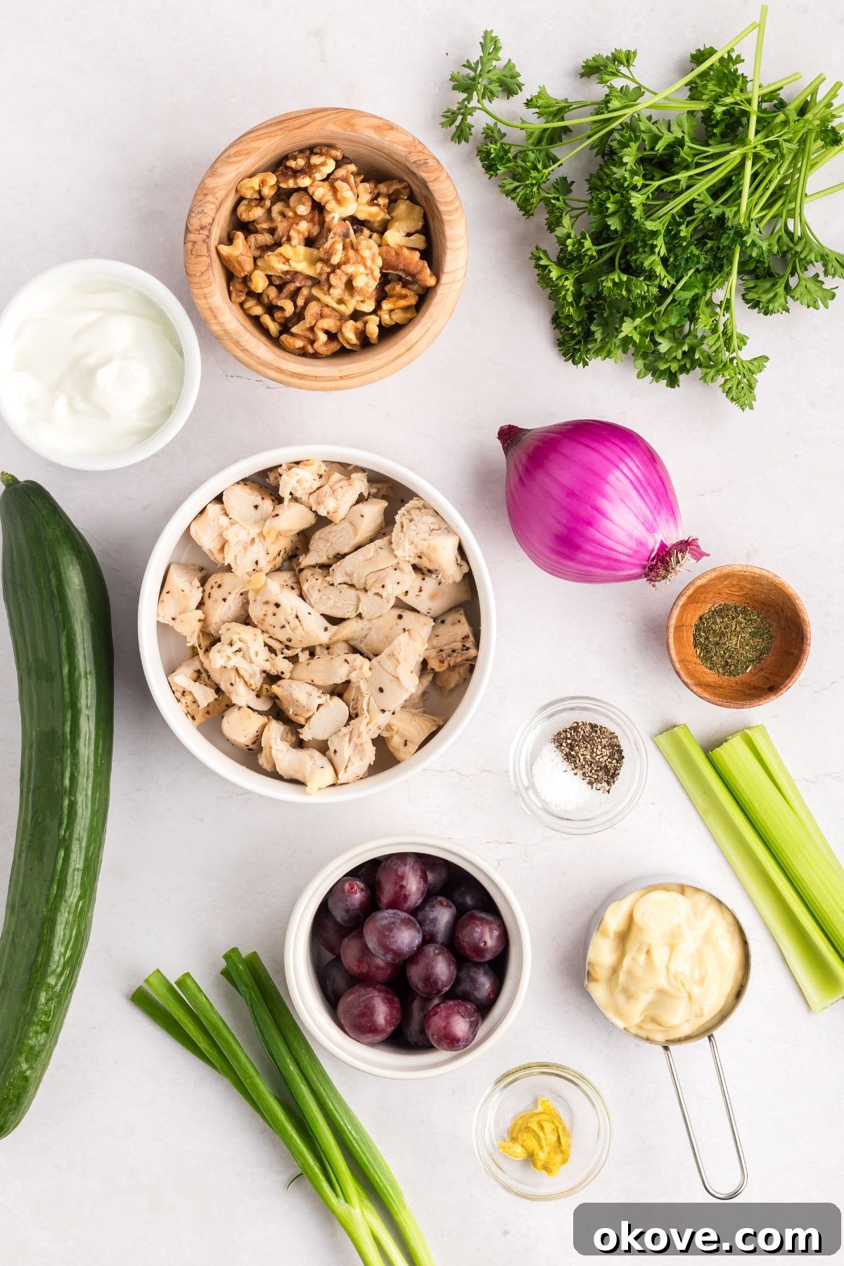 Orchard Chicken Salad 3 All the fresh ingredients meticulously measured and arranged in small bowls on an elegant marble countertop, ready to be combined for the chicken salad, showcasing vibrant colors.