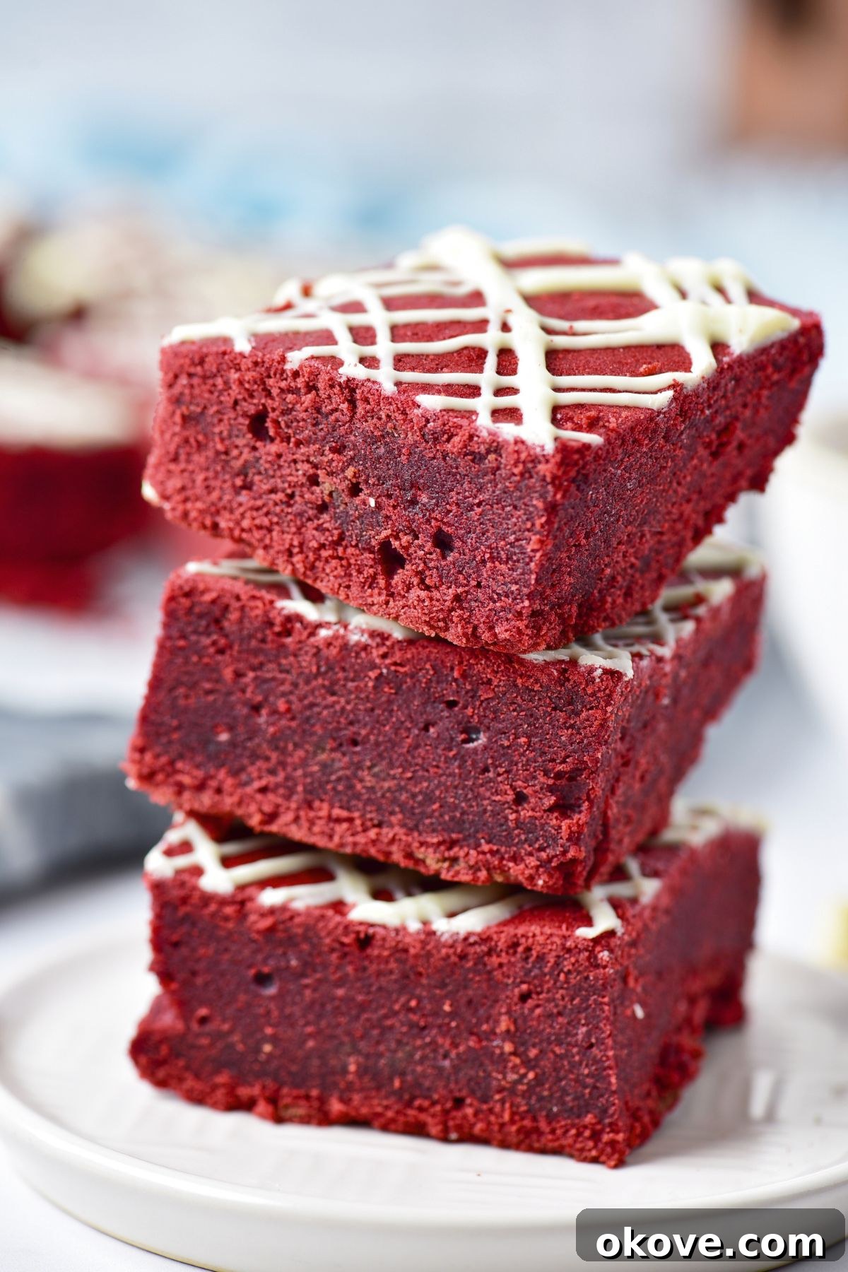 Crimson Velvet Brownies 2 Red velvet brownies cut into squares and stacked on a small white plate.