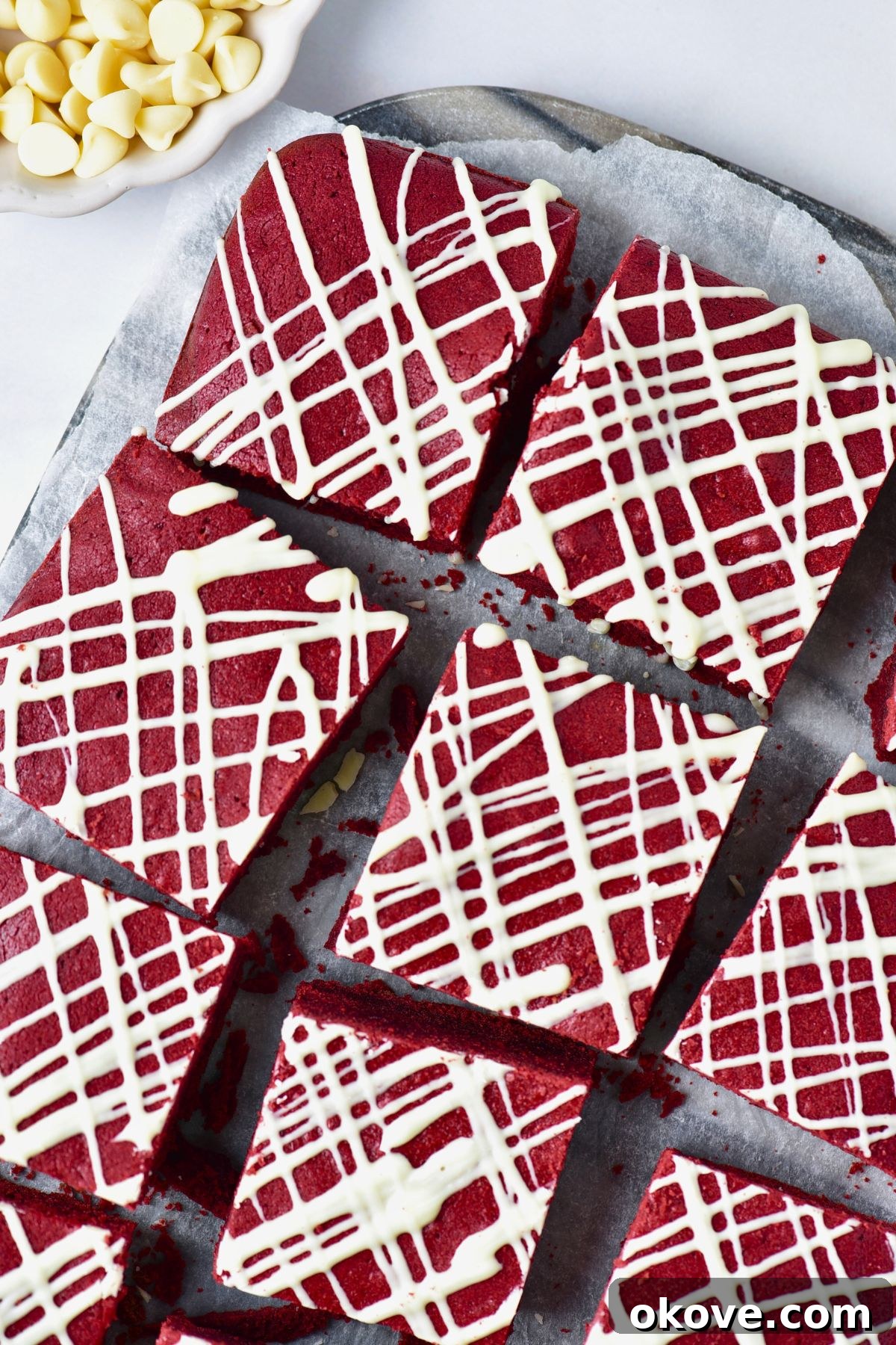 Crimson Velvet Brownies 7 Bright red brownies cut into squares with white chocolate drizzled on top.
