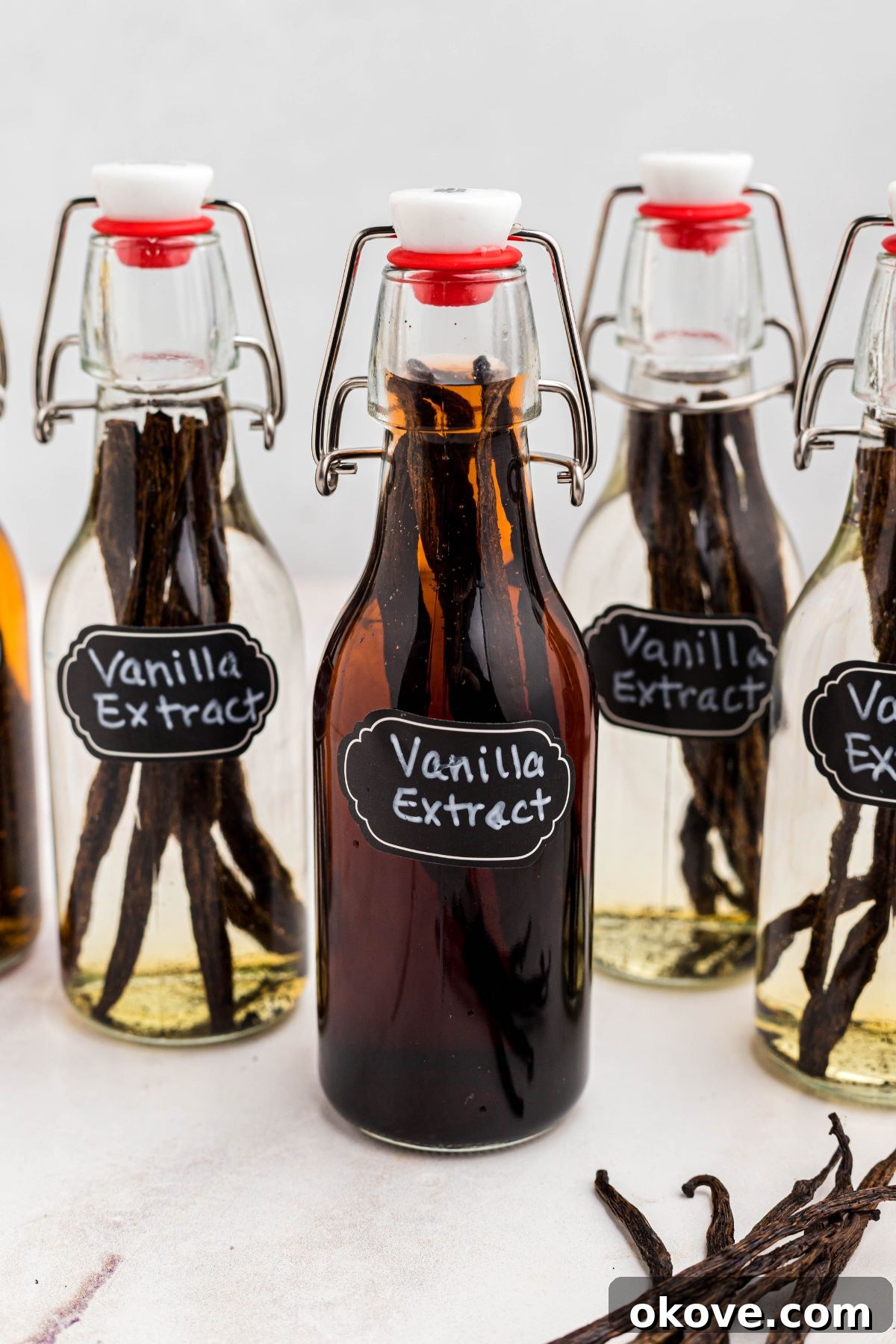 Handcrafted Vanilla Essence 2 Small glass bottle of homemade vanilla extract on a white marble table, ready for use or gifting.