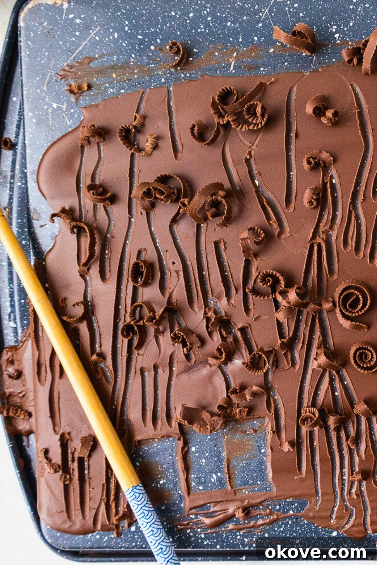 The Secret to Perfect Chocolate Curls 2 Chocolate spread onto a baking sheet, making chocolate curls.