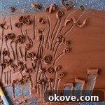 Chocolate spread onto a baking sheet, making chocolate curls.