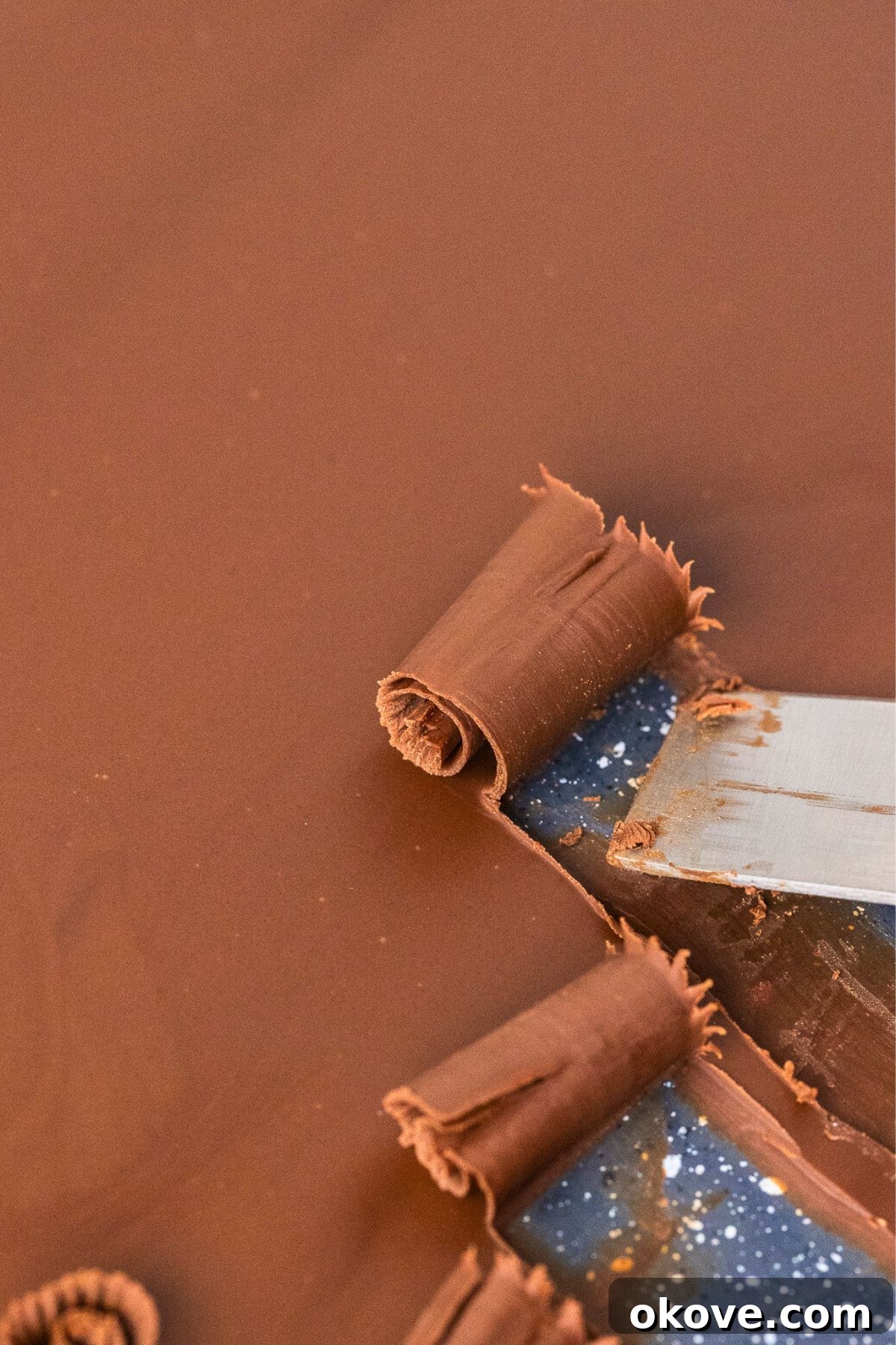 The Secret to Perfect Chocolate Curls 6 Large curls being made with an offset spatula.