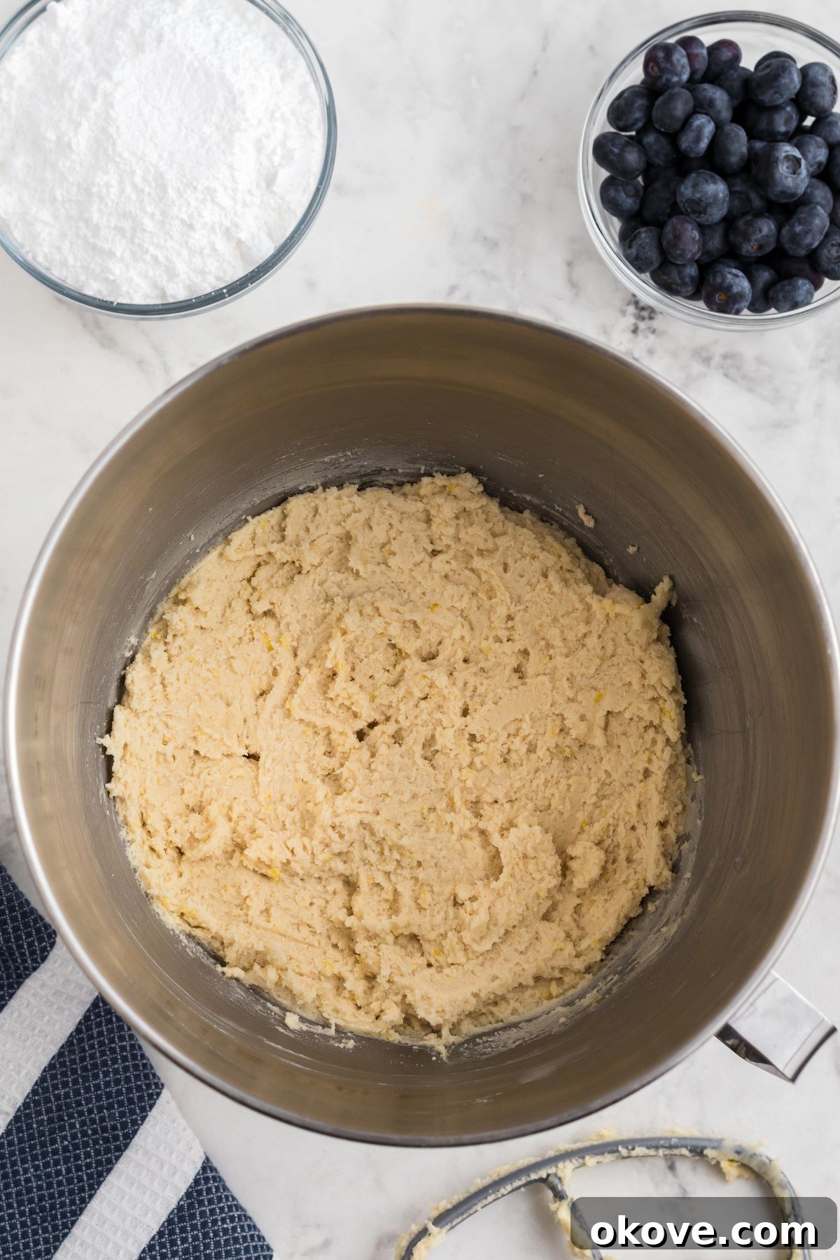 Tangy Blueberry Lemon Delights 6 Smooth, well-mixed cookie dough swirled in a silver mixing bowl, showcasing its creamy texture before the addition of blueberries.