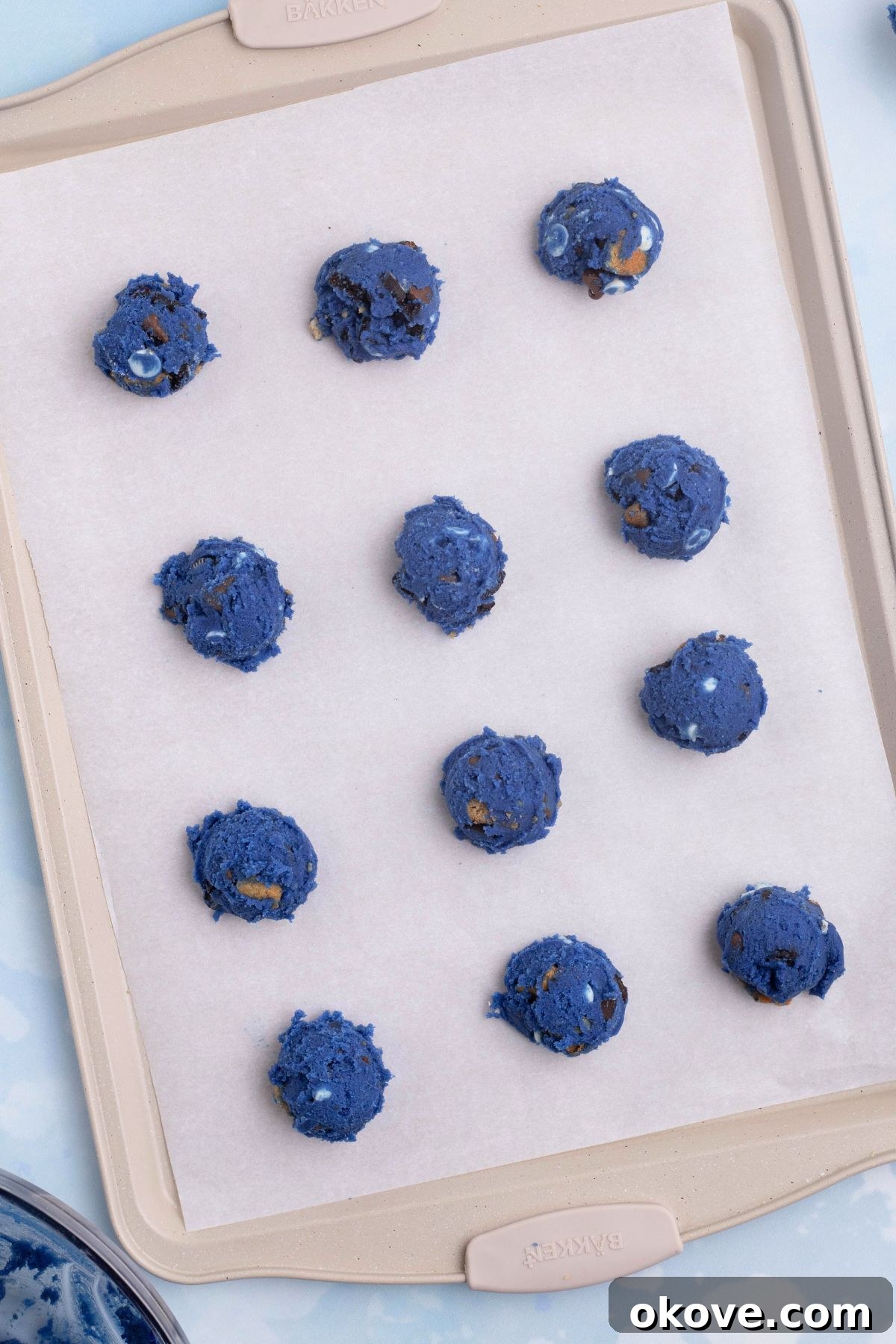 Blue Monster Munchies 7 Cookie dough scooped onto a baking sheet lined with parchment paper.