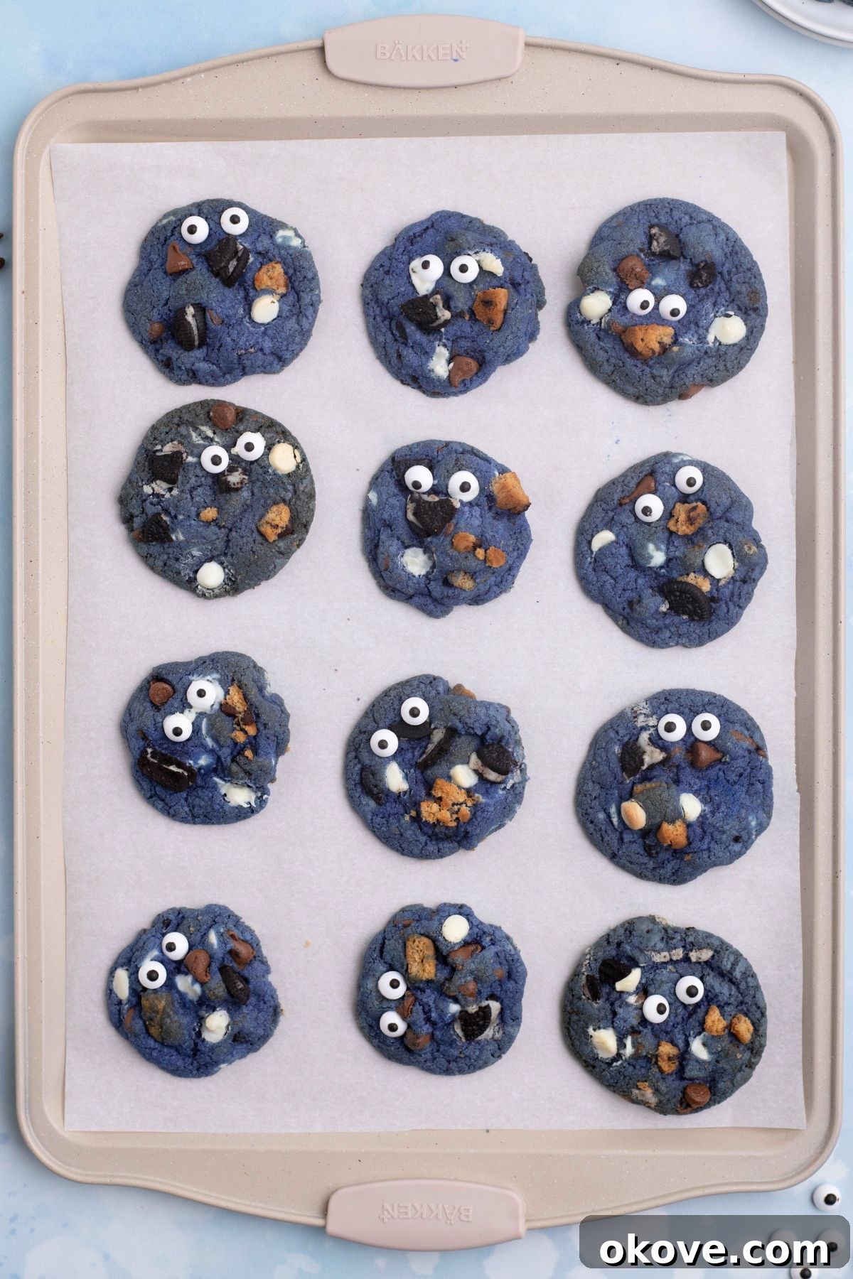Blue Monster Munchies 8 Baked cookies on a cookie sheet, lined with parchment paper.
