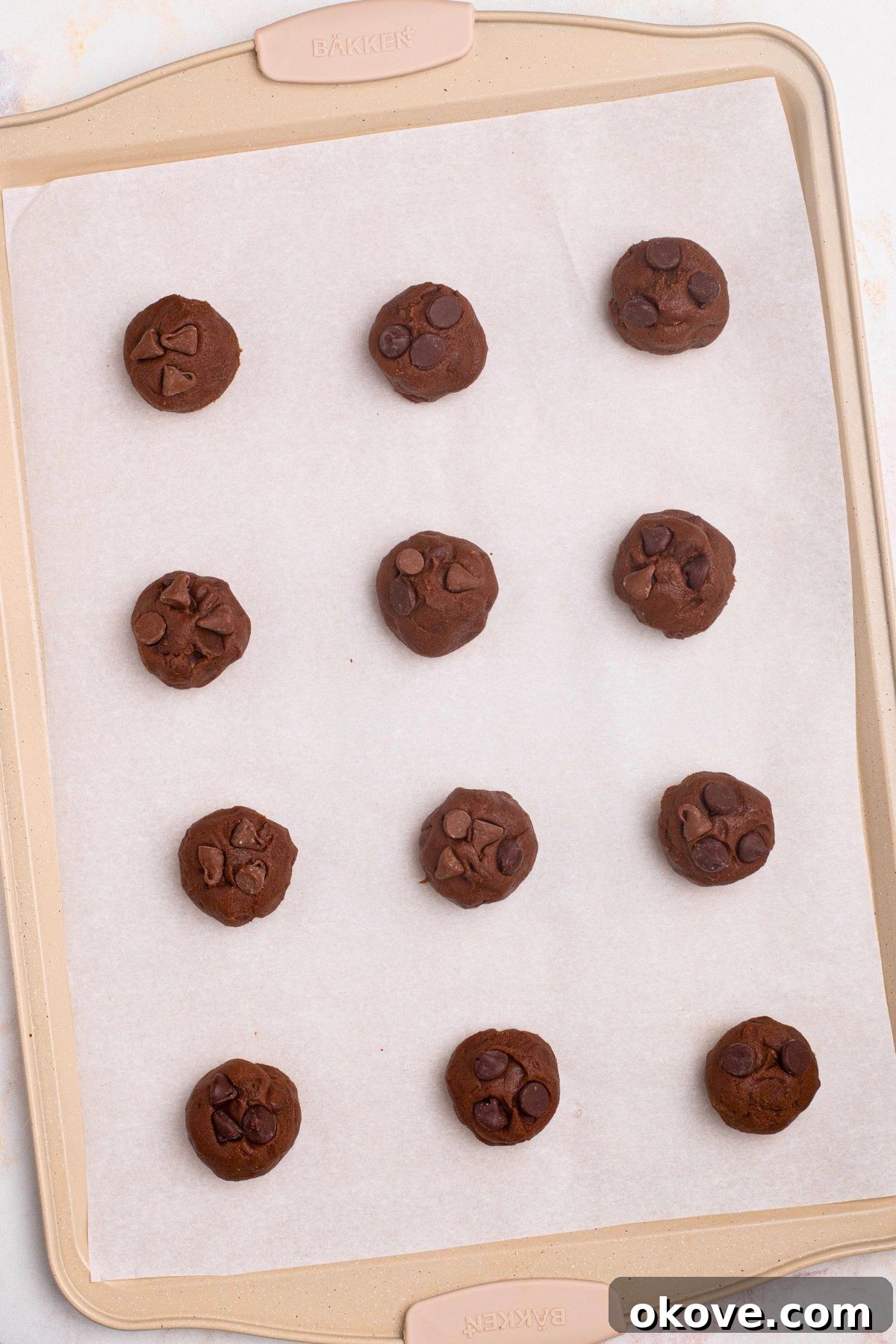 Luscious Double Chocolate Chip Cookies 7 Cookie dough balls evenly spaced on a parchment-lined baking sheet, ready for the oven.