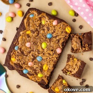 Easter brownies being cut into squares with candies on the table along with a pink linen.