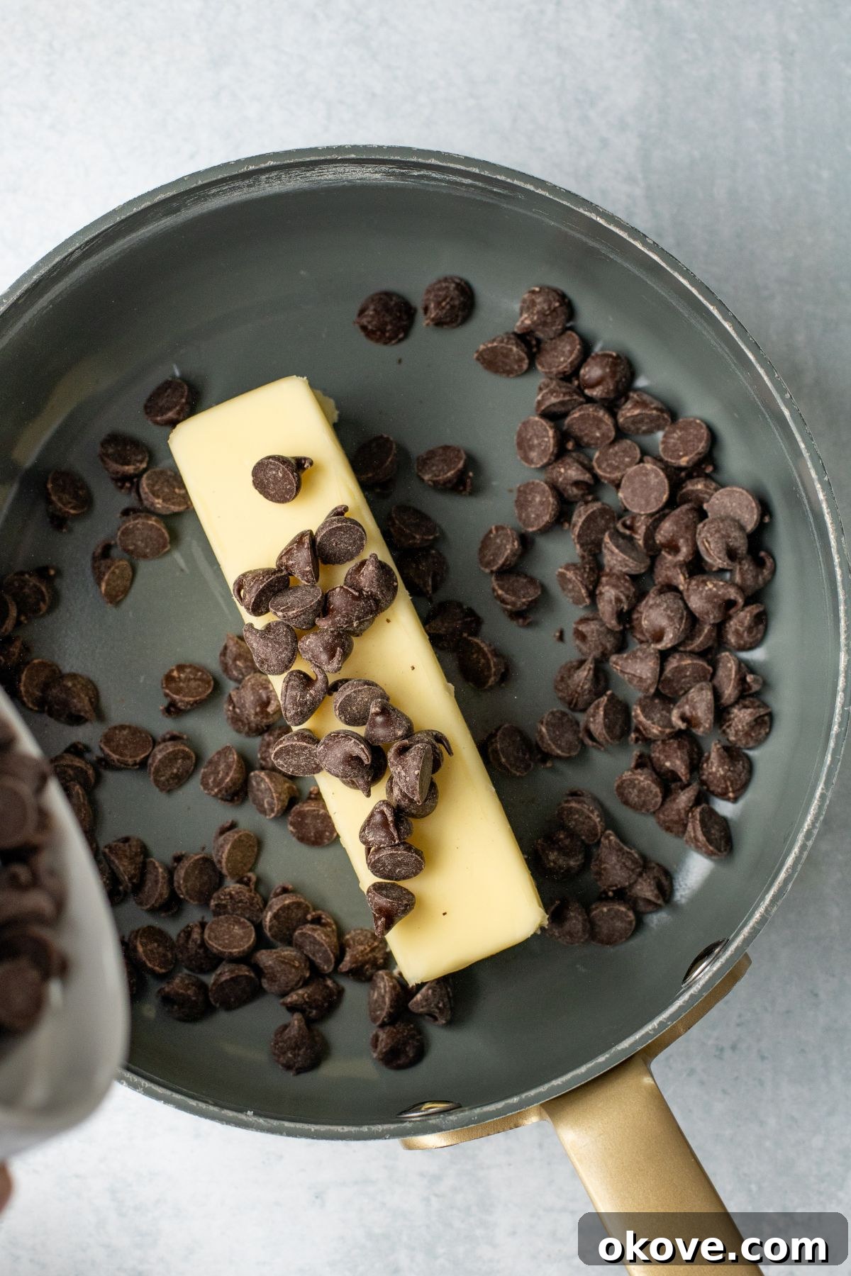 Butter and chocolate chips being melted together in a saucepan.
