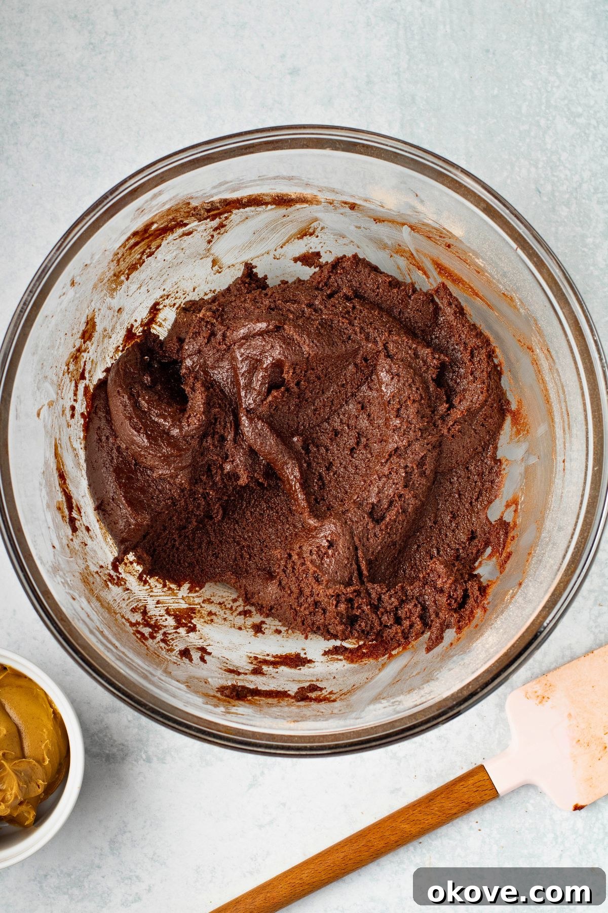 Brownie batter mixed together in a large glass mixing bowl.