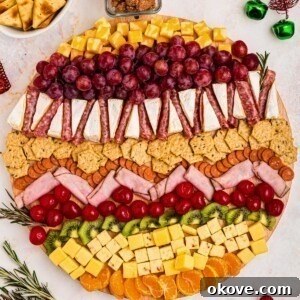 Meats, cheeses, and fruits on a board in the shape of an ornament.