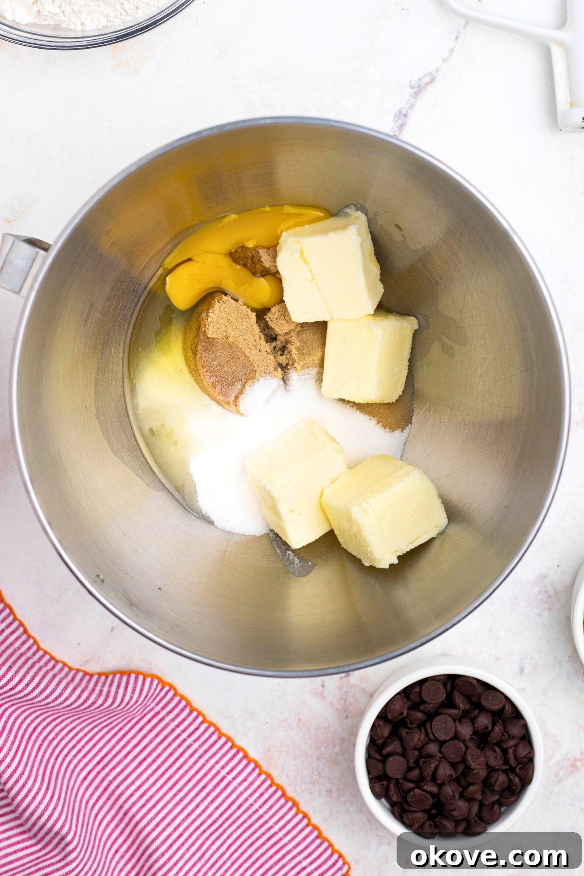 Butter, eggs, and sugars, in a mixing bowl before mixing together.