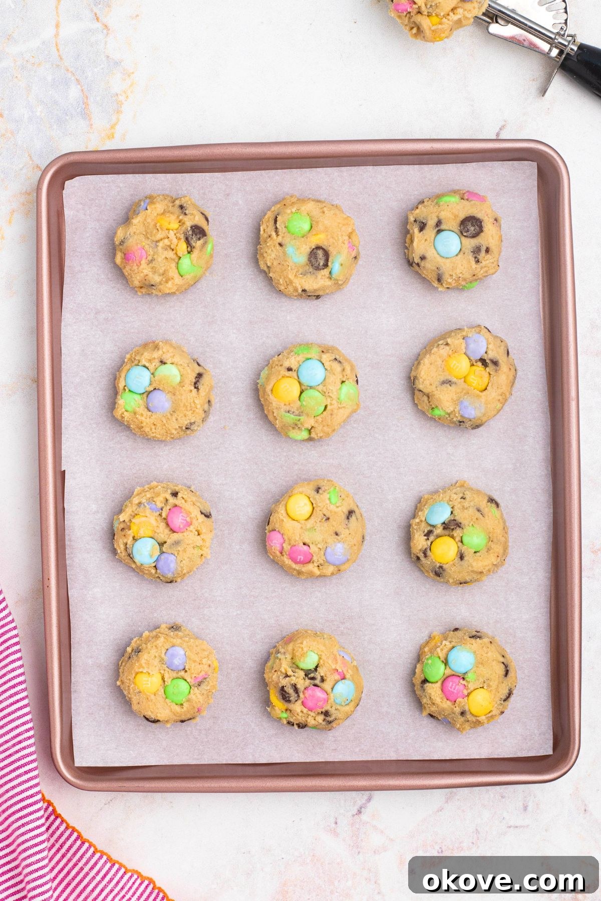 Cookie dough dropped onto a baking sheet before being baked.