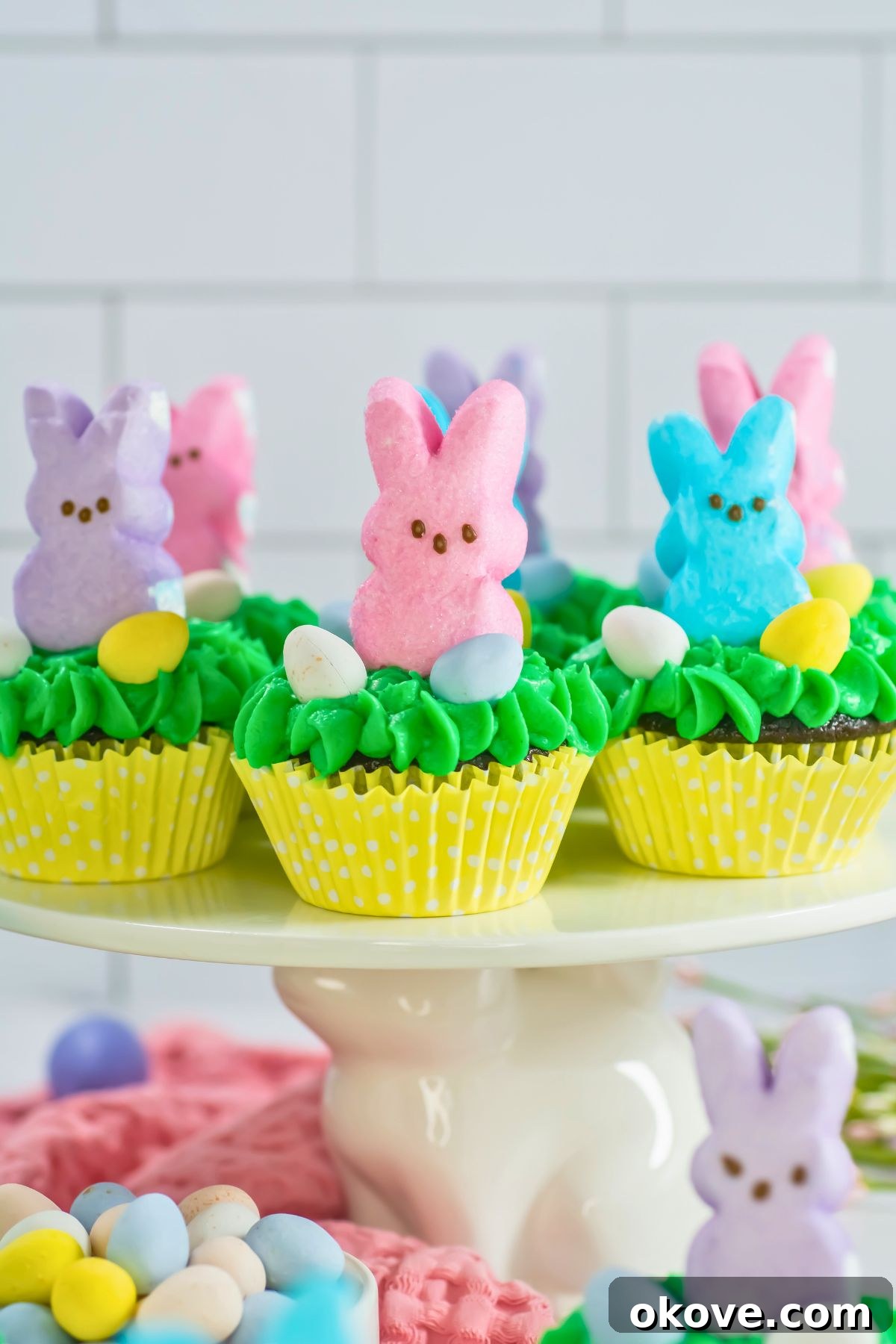 Colorful Peeps Cupcake Delights 2 Beautifully decorated Easter Peeps Cupcakes with green frosting and marshmallow bunnies, ready for celebration.