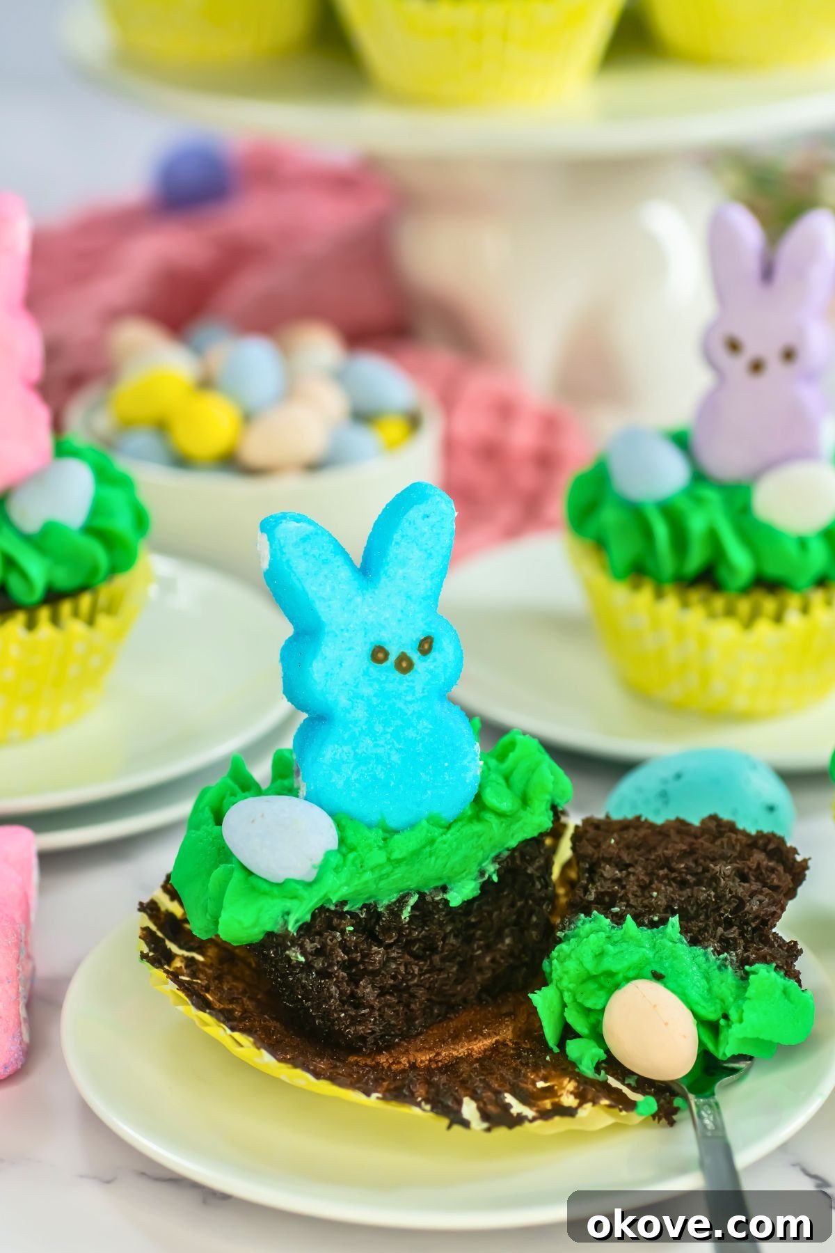 Colorful Peeps Cupcake Delights 10 Close-up of an Easter Peeps cupcake with a marshmallow bunny, a fork taking a bite, highlighting the moist texture.