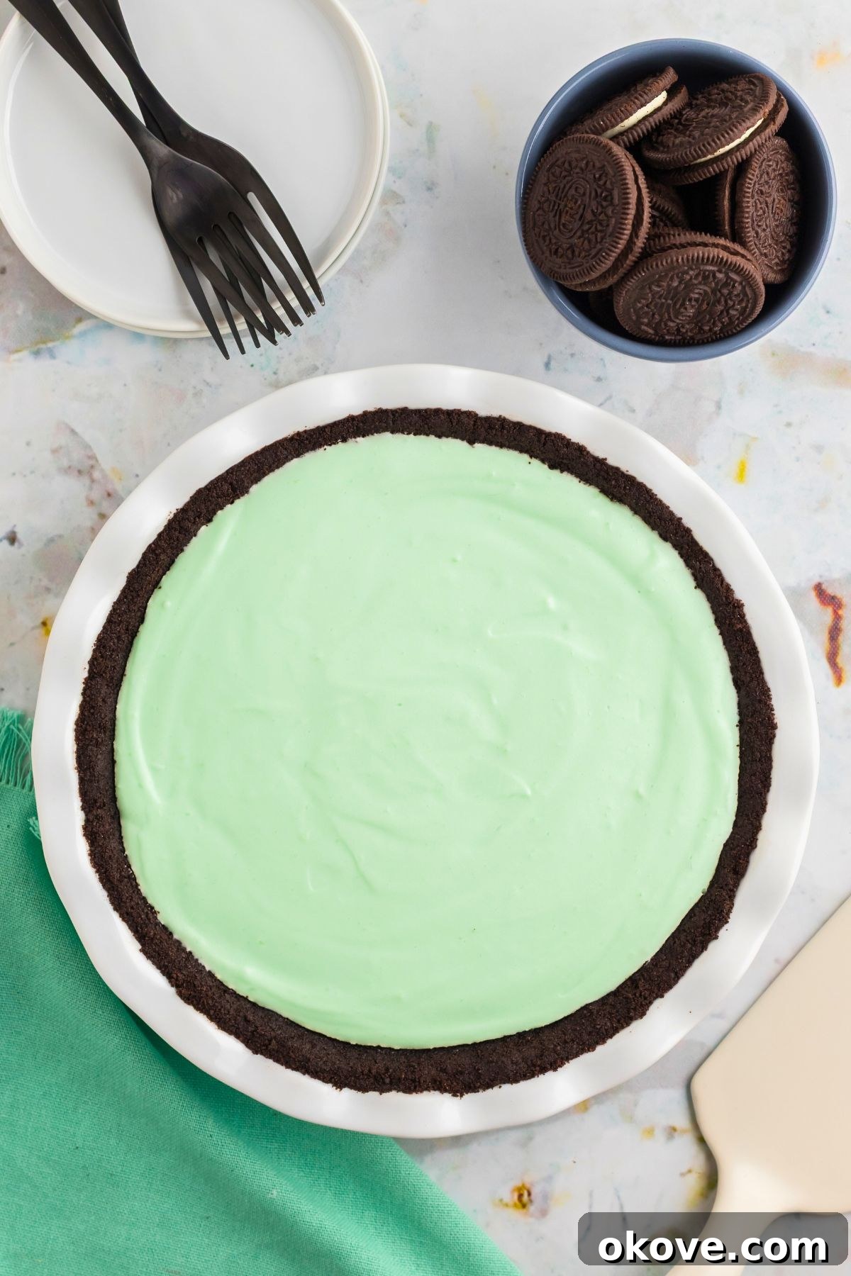 Minty Green Dream Pie 9 An unadorned Grasshopper Pie, freshly poured into a pristine white pie dish with its chocolate crust, chilling before the final garnishes are added.