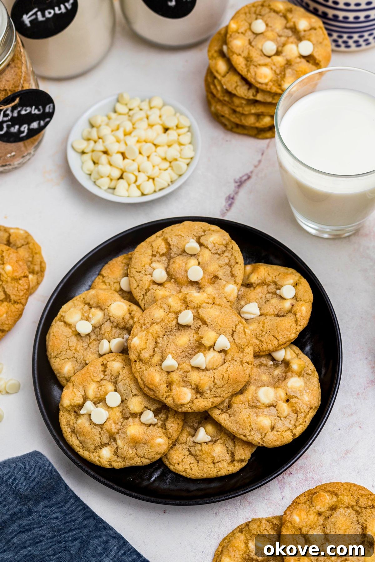 Golden white chocolate chip cookies arranged beautifully on a black plate, ready to be enjoyed.