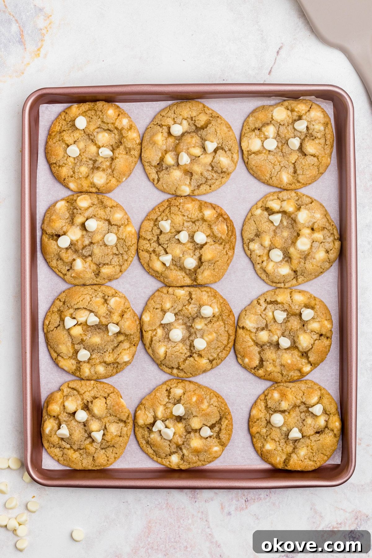 Beautifully baked golden cookies resting on a stylish rose gold baking sheet, cooling down after being removed from the oven.