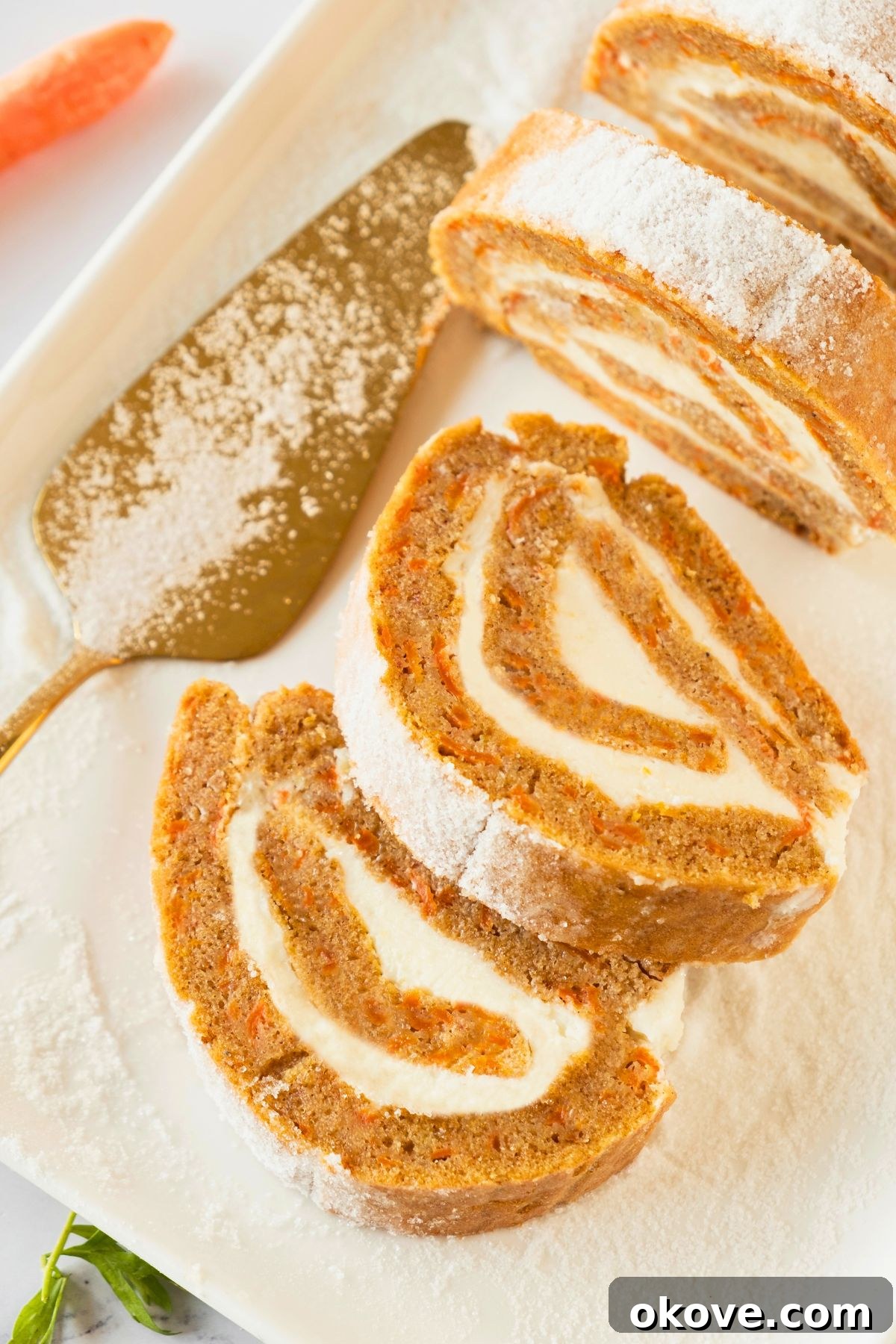 Spiced Carrot Roulade 2 Golden moist carrot cake roll filled with creamy cream cheese frosting, ready to be sliced.