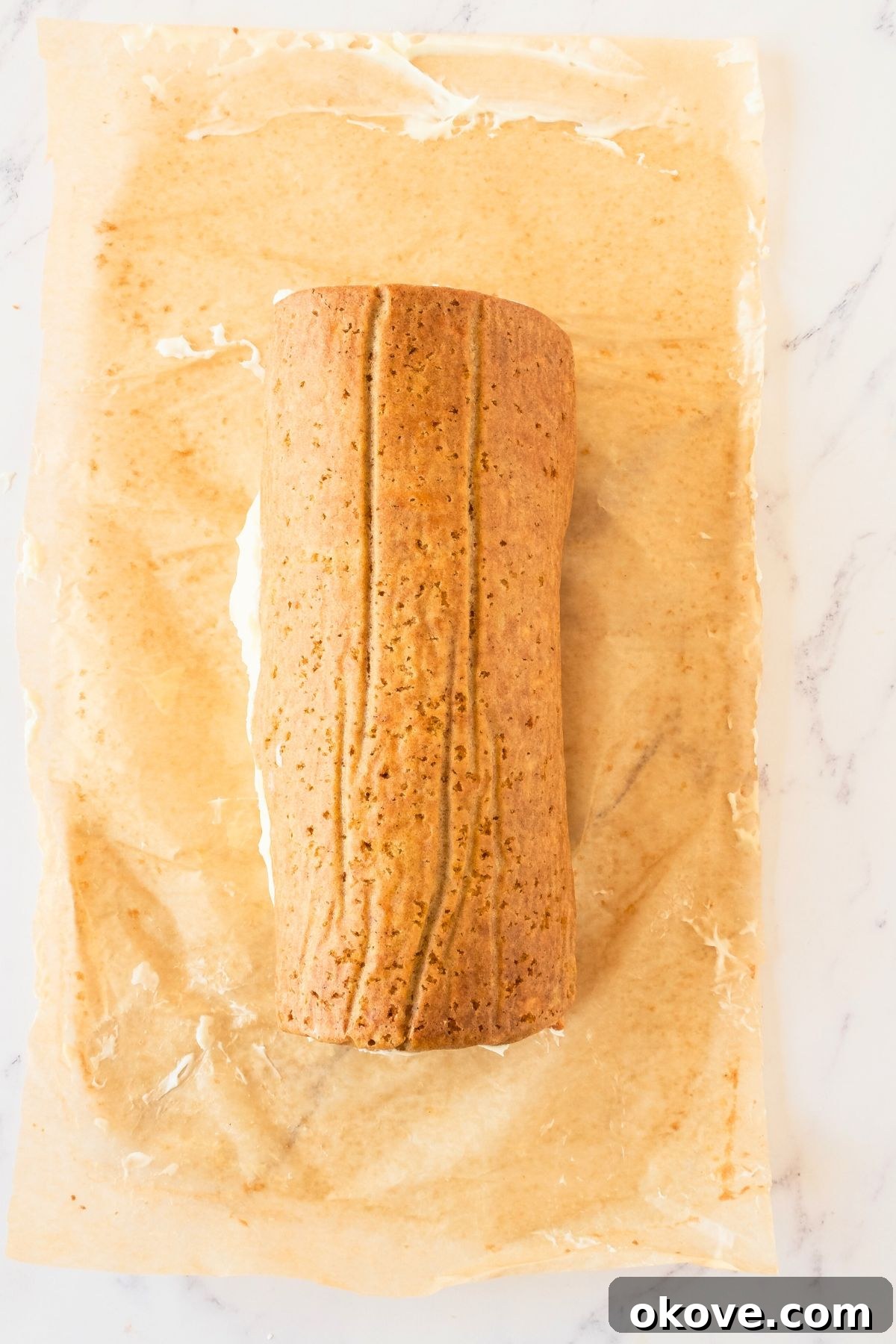 Spiced Carrot Roulade 7 A freshly rolled carrot cake with cream cheese filling visible on the inside, ready for chilling.